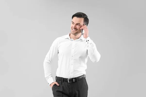 Портрет Красивого Бизнесмена Разговаривающего Мобильному Телефону Сером Фоне — стоковое фото