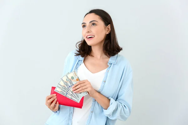 Junge Frau Mit Portemonnaie Und Geld Auf Hellem Hintergrund — Stockfoto