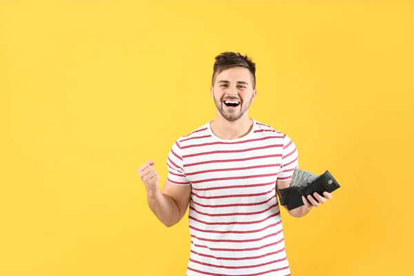 Happy man with purse on color background