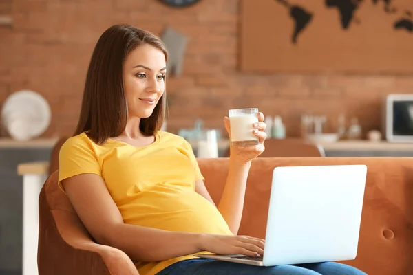 Красивая Беременная Женщина Ноутбуком Пьет Молоко Дома — стоковое фото