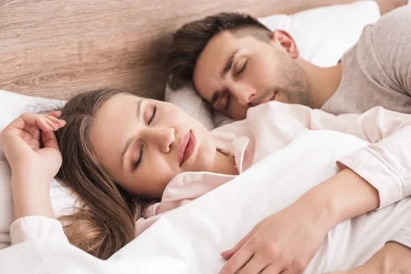 睡在床上的年轻夫妇 — 图库照片