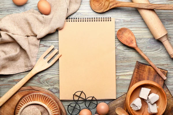 Cook book with products on wooden background