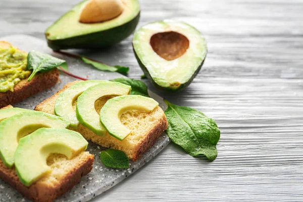 Masada lezzetli avokado sandviçleri olan bir pano.