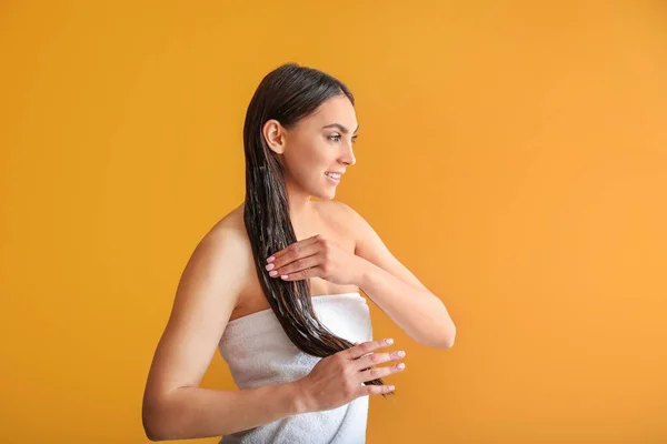 Hermosa Mujer Joven Aplicando Aceite Coco Cabello Contra Fondo Color — Foto de Stock