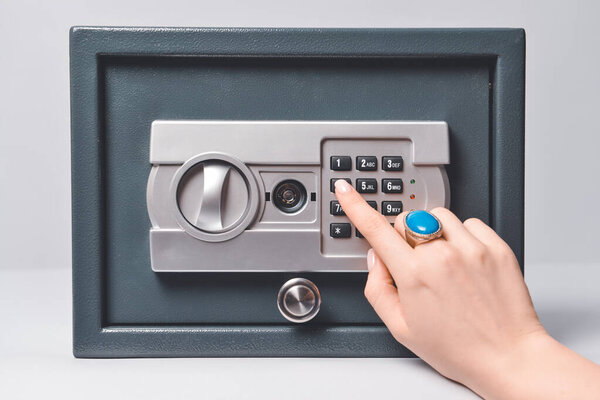 Женщина открывает сейф на светлом фоне
