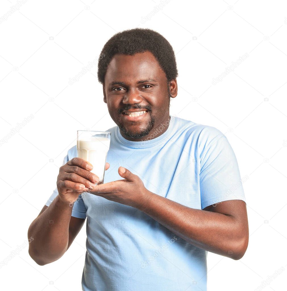 Young African-American man with milk on white background