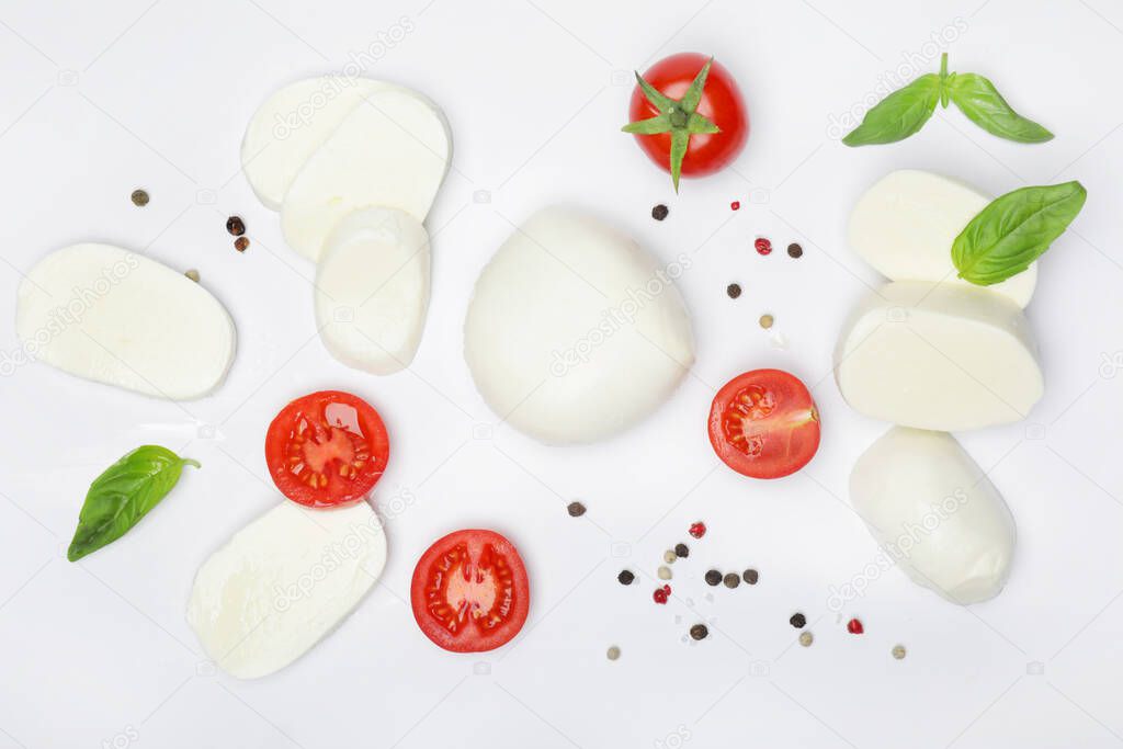 Mozzarella cheese with basil, spices and tomatoes on white background