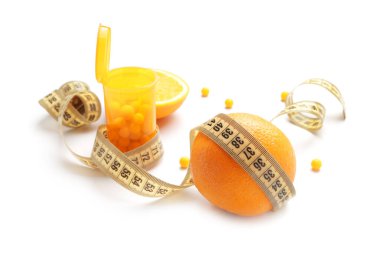 Kilo verme hapları, portakal meyvesi ve beyaz arka planda mezura.