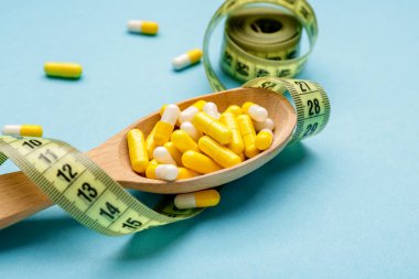 Kilo verme haplı kaşık ve arka planda mezura