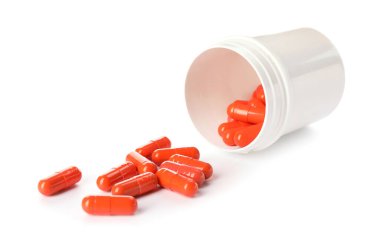 Beyaz arka plan üzerinde haplarla şişe