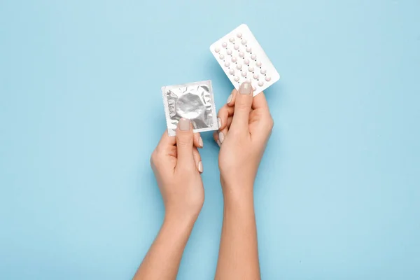 Vrouwelijke Handen Met Anticonceptiepillen Condoom Kleur Achtergrond — Stockfoto