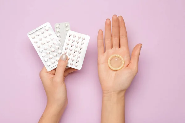 Manos Femeninas Con Píldoras Anticonceptivas Condón Sobre Fondo Color — Foto de Stock