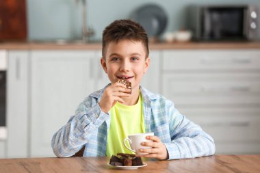Mutfakta çikolata yiyen tatlı küçük çocuk.