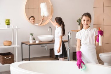 Küçük şirin oda hizmetçileri banyoyu temizliyor.