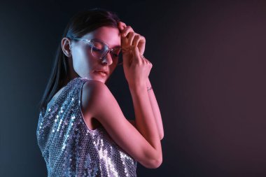 Koyu arkaplanda güzel bir genç kadının tonlu portresi.