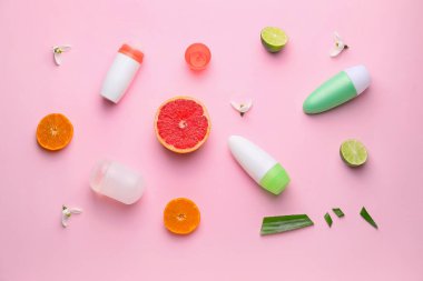 Renkli arkaplanda farklı deodorantlar ve turunçgil meyveleri