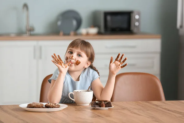 かわいいです女の子食べるチョコレートでキッチン — ストック写真