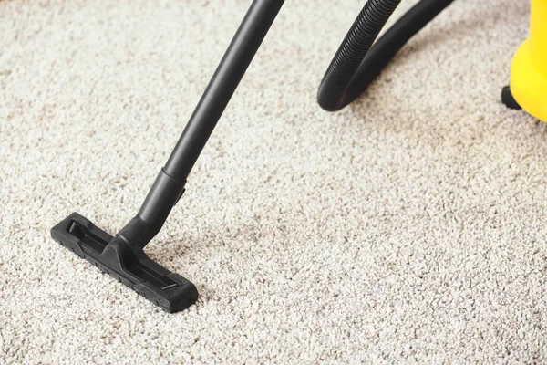 Hoovering of carpet in room