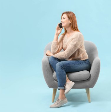 Koltukta otururken telefonla konuşan güzel bir kadın.