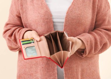 Renkli arka planda boş cüzdanı olan son sınıf öğrencisi kadın, yakın plan.