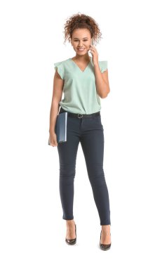 Genç Afro-Amerikalı iş kadını beyaz arka planda telefonla konuşuyor.