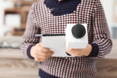 Mikrofonlu küçük gazeteci ofiste röportaj yapıyor, yakın plan.