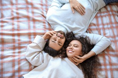 Mutlu genç çift evde yatakta yatıyor.