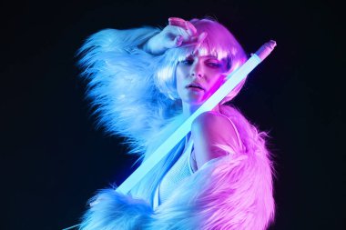 Koyu arkaplanda neon lambalı güzel bir kadının tonlu portresi.