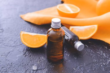 Koyu arkaplanda portakal suyu olan şişeler.