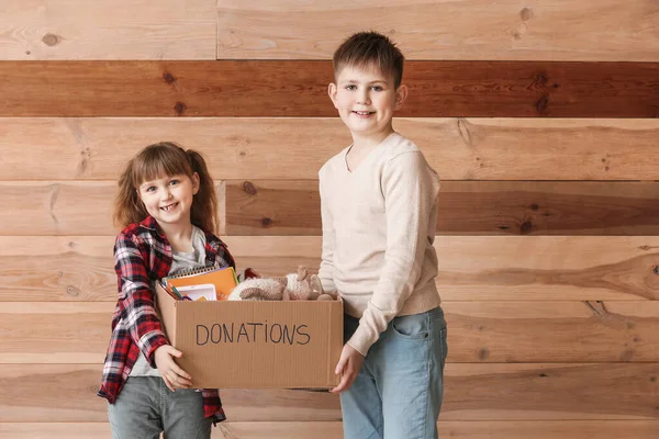 Niños Pequeños Con Donaciones Sobre Fondo Madera —  Fotos de Stock
