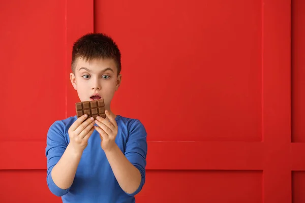 Surprised Little Boy Eating Chocolate Color Background — Stock Photo, Image