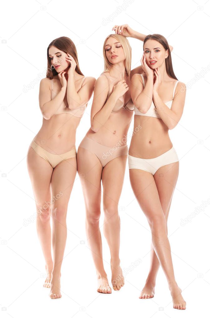 Beautiful young women in underwear on white background