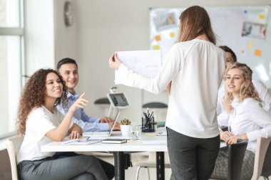 Kadın iç mimar ofiste gençlere öğretmenlik yapıyor