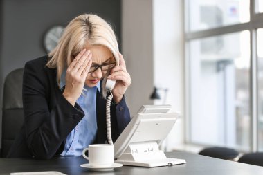 Stresli olgun kadın işten çıkarılması hakkında telefonla bilgilendiriliyor.
