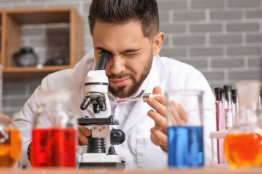 Erkek simyacı laboratuarda çalışıyor.