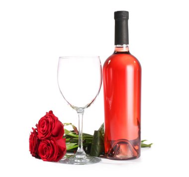 Beyaz arka planda gül çiçekleri olan bir bardak şarap.