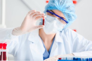 Doktor laboratuvarda kan örnekleriyle çalışıyor.