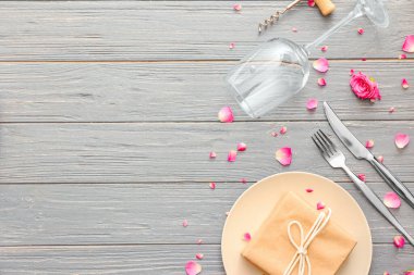 Şarap kadehi ve servis masasının üzerinde hediye kutusu.