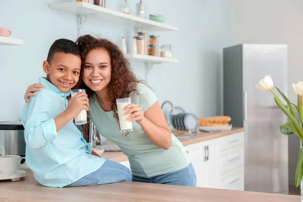 非洲裔美国妇女和她的儿子在厨房喝牛奶 — 图库照片