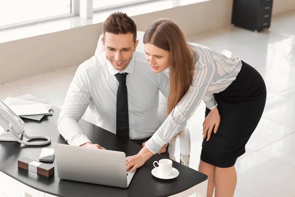 Boss and his beautiful secretary working in office