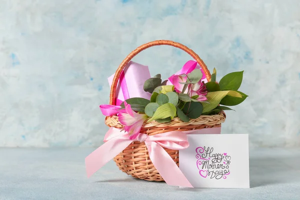 Basket with gifts for Mother\'s Day on color background