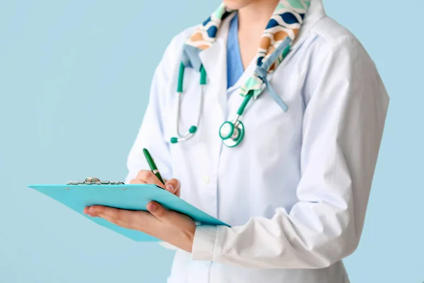 女性医師とともに聴診器とクリップボード上の色背景 — ストック写真
