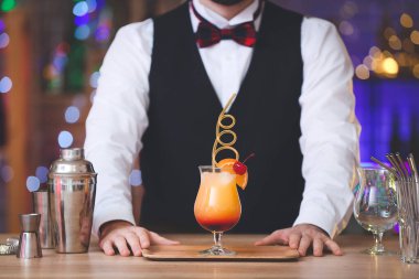 Barda lezzetli bir kokteyl içen erkek barmen.