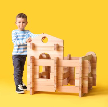 Küçük çocuk renk arka planında sökülmüş evle oynuyor