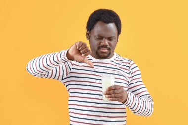 Arka planda süt ürünlerine alerjisi olan genç bir Afro-Amerikalı.