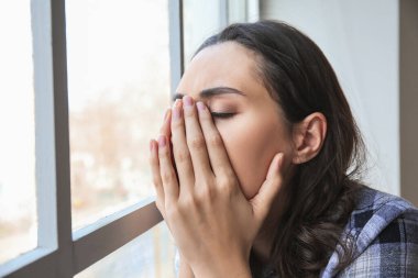 Pencerenin yanındaki depresif genç kadın