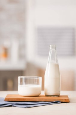 Masada bir bardak ve bir şişe taze süt.