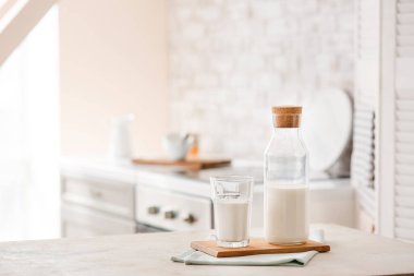 Masada bir bardak ve bir şişe taze süt.