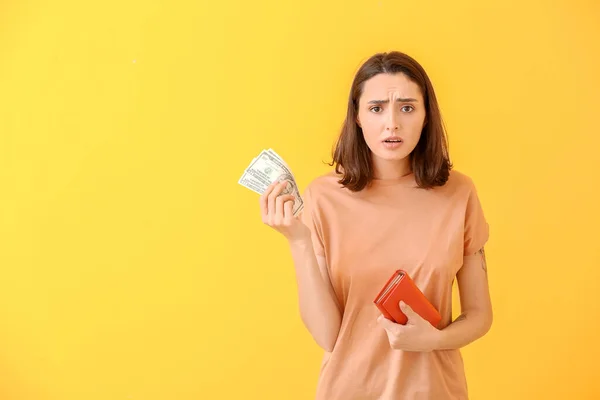 Traurige Junge Frau Mit Geldbörse Und Geld Auf Farbigem Hintergrund — Stockfoto