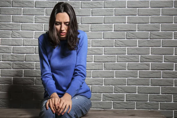Depressive Junge Frau Sitzt Nahe Ziegelmauer — Stockfoto